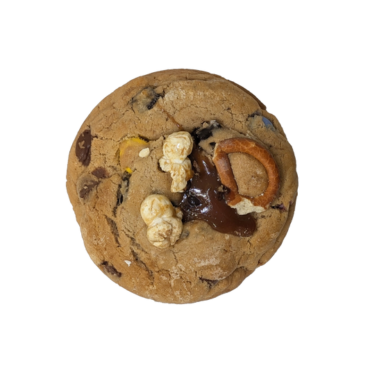 Picture of a cookie stuffed with soft caramel and topped with popcorn, pretzels and toffee.