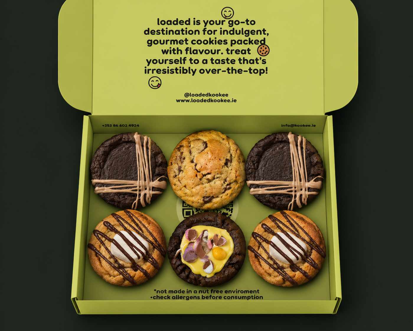 picture of a green open selection box showing the contents, six delicious stuffed cookies with various fillings and toppings