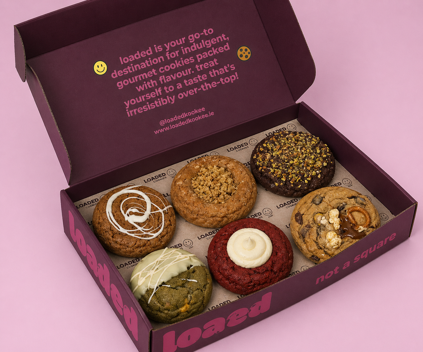 picture of a purple open selection box showing the contents, six delicious stuffed cookies with various fillings and toppings