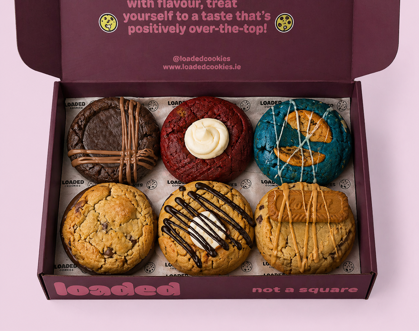 picture of a dark red open selection box showing the contents, six delicious stuffed cookies with various fillings and toppings