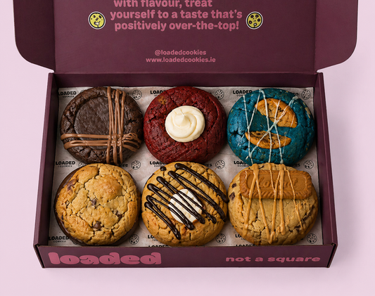 picture of a dark red open selection box showing the contents, six delicious stuffed cookies with various fillings and toppings