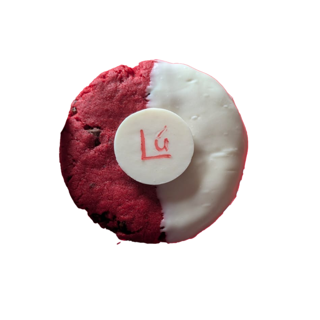 Picture of a cookie stuffed with milk, dark and white chocolate, half dipped in white chocolate, and decorated with a Lú branded button