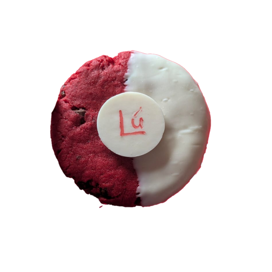 Picture of a cookie stuffed with milk, dark and white chocolate, half dipped in white chocolate, and decorated with a Lú branded button